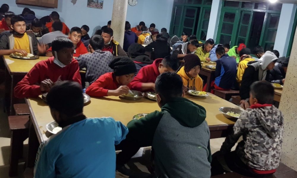Drengene fra Albella Boys Home er samlet til aftensmad i børnehjemmets spisesal.